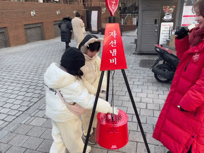 최은성(9), 최예승(6) 자매가 자선냄비에 모금액을 넣고 캐틀메이트에게 인사를 하고 있다./영상=이정우 기자.