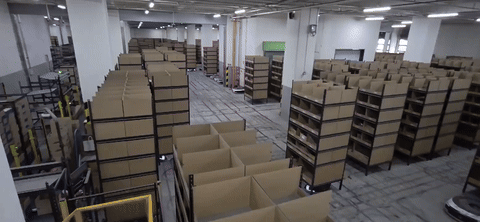 CJ대한통운 군포센터 스마트층에서 AGV가 상품 선반을 작업자에게 이송하고 있다. (사진=한전진 기자)