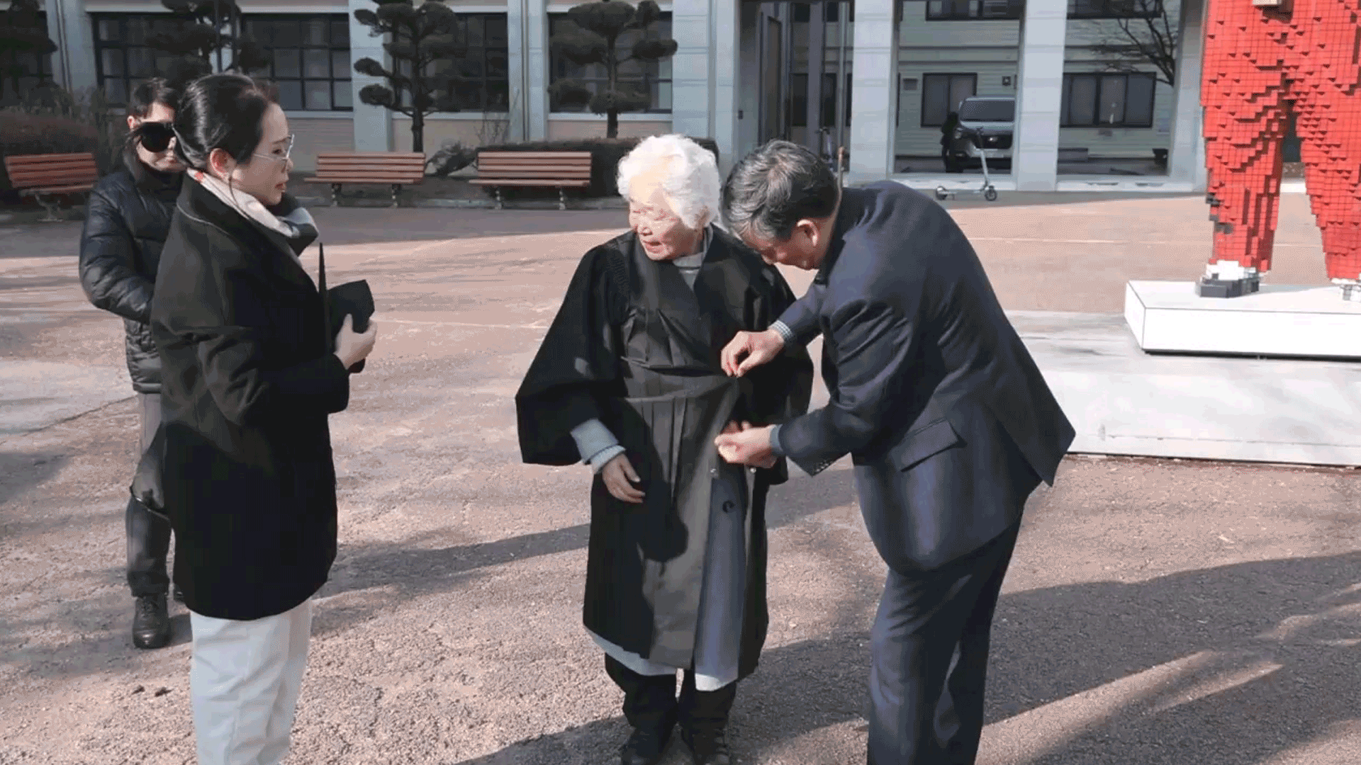 ‘85세 대학생’ 이군자 할머니가 가족의 도움을 받아 학사복을 입고 있다.