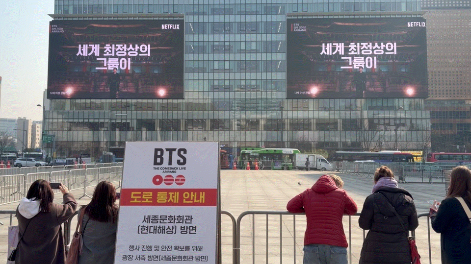 외국인 관광객들이 넷플릭스의 'BTS 컴백 라이브' 예고편을 보고 있다. / 영상=이수 기자
