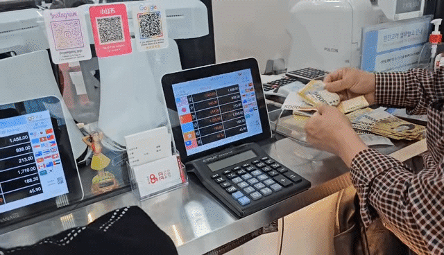 지난 24일 서울 명동의 한 환전소에서 한 손님이 달러를 원화로 바꿔 받은 후 5만원권 현금을 세고 있다. /황채영 기자