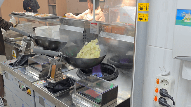 서울대 관악캠퍼스 학생식당 '아름드리' 조리실에서 만다린로보틱스의 '로보틱웍'이 웍질(웍을 들어 흔드는 동작)로 짜장소스 재료를 볶고 있다. 김대현 기자