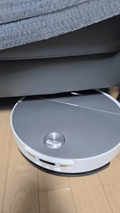 로보락 S10 맥스V 울트라가 소파 밑을 구석 구석 청소하고 있다.