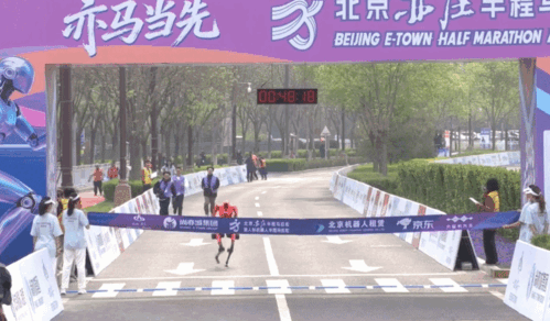 중국 스마트폰 제조사 아너의 휴머노이드 로봇 '샨뎬'이 19일 중국 베이징 이좡 퉁밍후 공원에서 열린 제2회 베이징 이좡 휴머노이드 로봇 하프 마라톤 결승 지점을 48분 19초로 통과하고 있다. 바이두 캡처