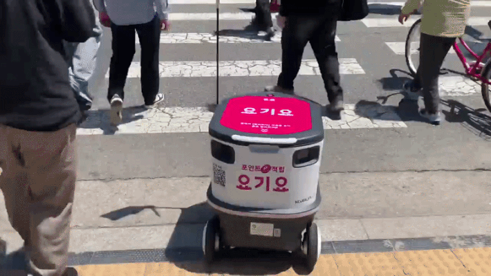 [서울=뉴시스]박재연 인턴기자=신호등이 초록불로 바뀌자 사람들과 함께 횡단보도를 건너는 요기요 배달로봇. 2026.05.13 *재판매 및 DB 금지