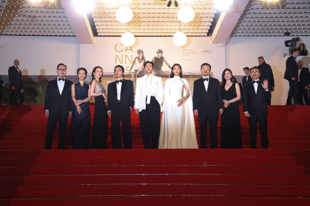 Director Yeon Sang-ho and cast members Jun Ji-hyun, Ji Chang-wook, Koo Kyo-hwan, Shin Hyun-bin, and Kim Shin-rok posing on the red carpet at the official premiere of 'Swarm' at the 79th Cannes Film Festival Midnight Screening.