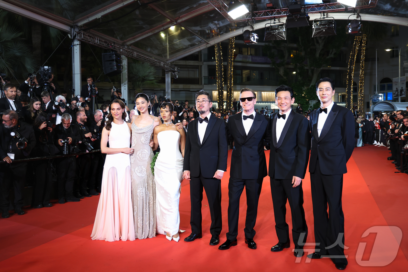 Will Cannes Choose 'Hope' on Closing Night? 6 Director Na Hong-jin and the cast pose on the red carpet at the Lumiere Grand Theatre in Cannes, France, on May 17 (local time). From left: Alicia Vikander, Jung Ho-yeon, Taylor Russell, Director Na Hong-jin, Michael Fassbender, Hwang Jung-min, and Jo In-sung.
