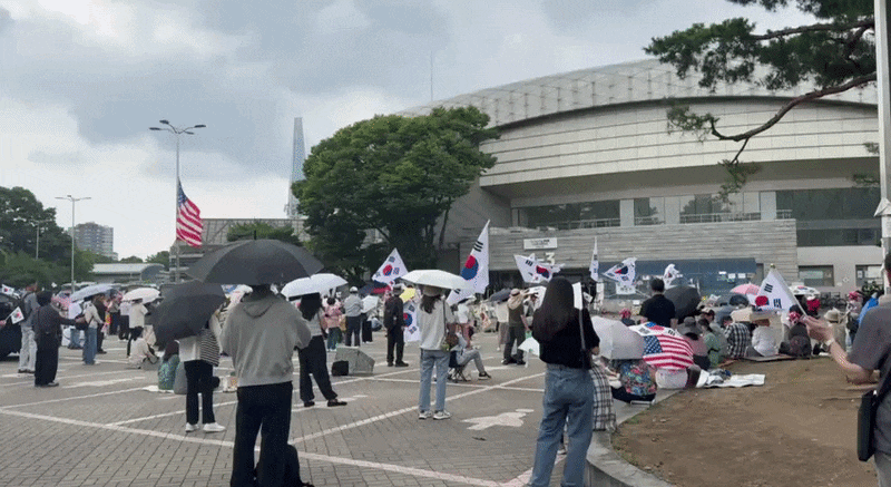 지난 3일 오후 12시쯤 서울 송파구 잠실 올림픽공원 핸드볼경기장 앞에서 시민들이 태극기와 성조기를 흔들며 구호를 외치고 있다. /현정민 기자